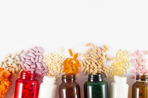 Assorted dietary supplements and vitamins in bottles, promoting spinal health and chiropractic care.