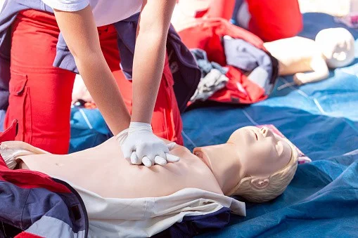 Emergency CPR training session with a healthcare professional demonstrating lifesaving techniques on a medical mannequin at the Scoliosis Center of LA & Chiropractic.