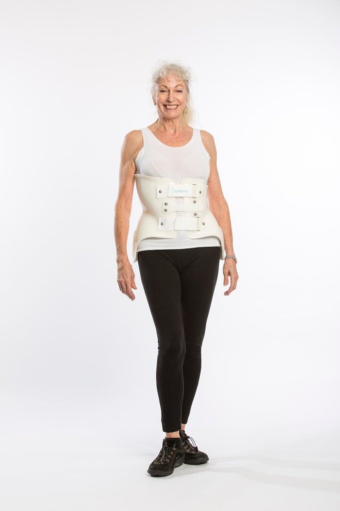 Elderly woman with scoliosis brace smiling, demonstrating adult scoliosis treatment options at the Scoliosis Center of LA & Chiropractic.